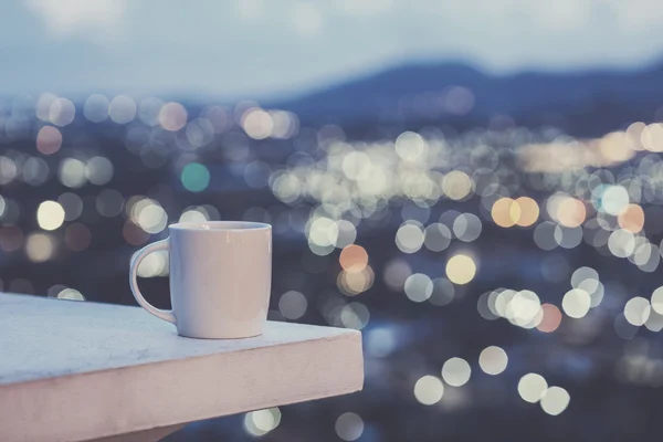 White coffee cup on counter and colorful blur light bokeh of cit — Φωτογραφία Αρχείου