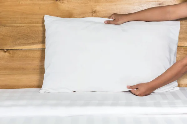Almohada blanca colocada a mano sobre sábana en habitación de hotel — Foto de Stock