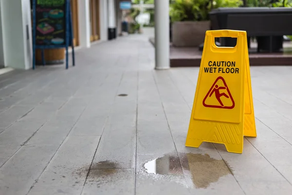 Segnale di avvertimento pavimento bagnato giallo sul pavimento in hotel — Foto Stock