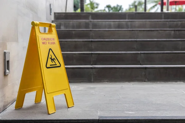 Yellow wet floor warning sign on the floor in hotel — Stock Photo, Image