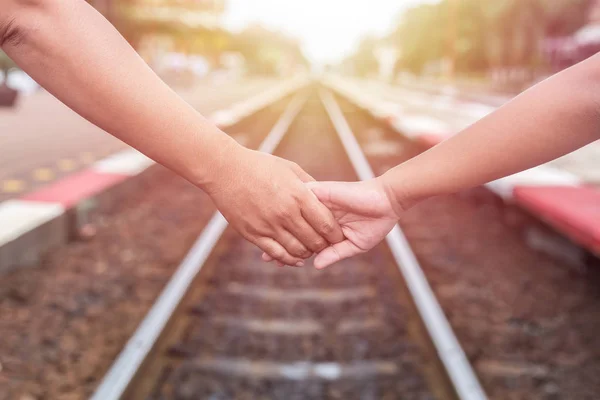 Žena držící ruku její dcery na železnici — Stock fotografie