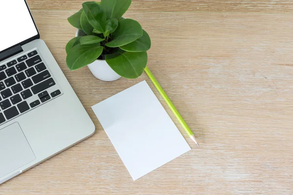 Laptop con carta bianca bianca bianca su scrivania in legno — Foto Stock