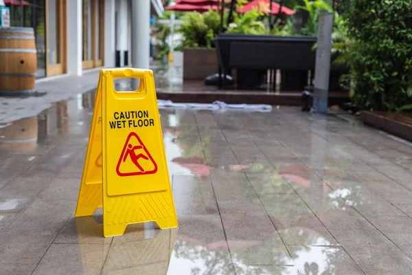 Señal de advertencia de suelo húmedo amarillo en el piso del hotel —  Fotos de Stock