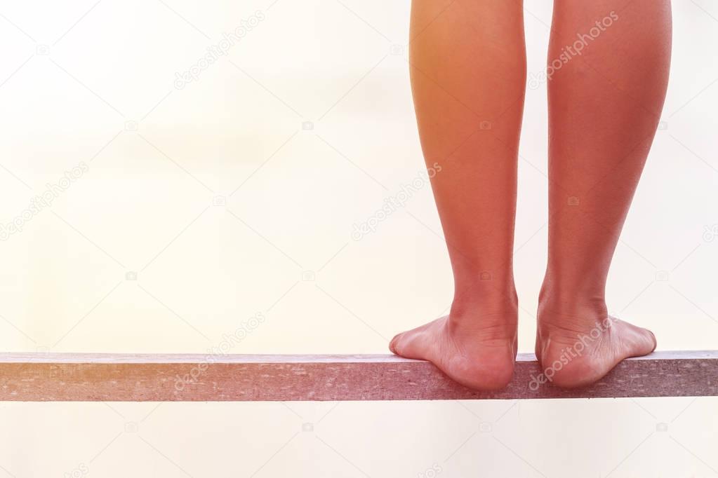 Bare feet standing on wooden bridge. Suicide concept