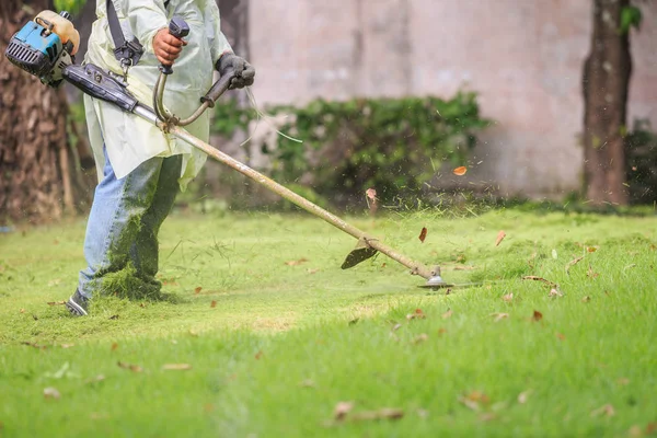 Ο άνθρωπος να κόψει τη χλόη με φορητή μηχανή στον κήπο — Φωτογραφία Αρχείου