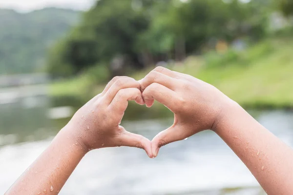 Våta händer med hjärtat skylt vid floden i Thailand — Stockfoto