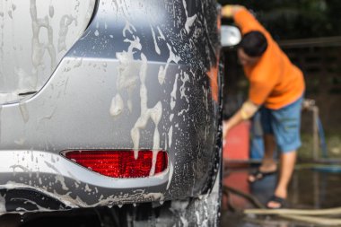 Araba araba bakım dükkanda yıkama için SOAP'ı kullanarak bir adam