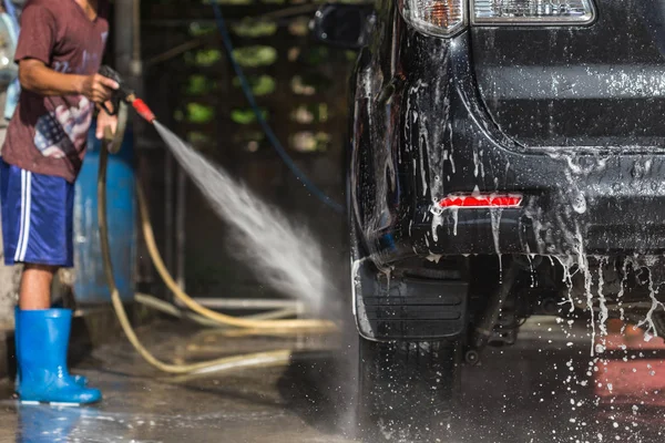 Ο άνθρωπος ψεκασμό πλυντήριο πίεσης για πλύσιμο αυτοκινήτων αυτοκίνητο περίθαλψη κατάστημα. Focu — Φωτογραφία Αρχείου