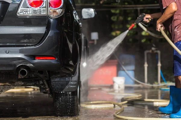 Homme pulvérisation de lavage sous pression pour lavage de voiture dans l'atelier de soins de voiture. Focu — Photo