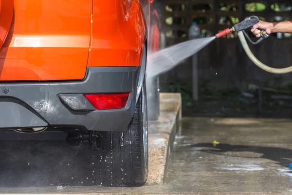 Man spraying pressure washer for car wash in car care shop. Focu — Stock Photo, Image