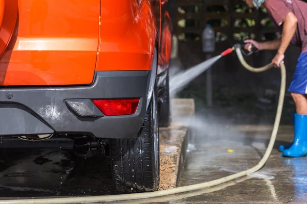 Ο άνθρωπος ψεκασμό πλυντήριο πίεσης για πλύσιμο αυτοκινήτων αυτοκίνητο περίθαλψη κατάστημα. Focu — Φωτογραφία Αρχείου
