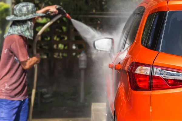 Homme pulvérisation de lavage sous pression pour lavage de voiture dans l'atelier de soins de voiture. Focu — Photo