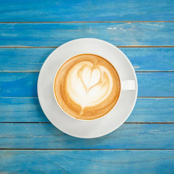 Top vista café quente latte em copo branco em azul vintage de madeira ta — Fotografia de Stock