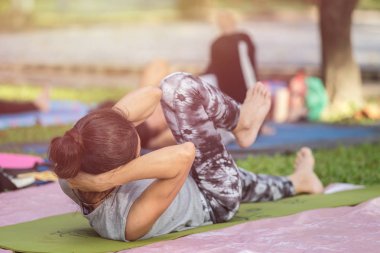 Asyalı kadın yoga yaparken ya da egzersiz parkta