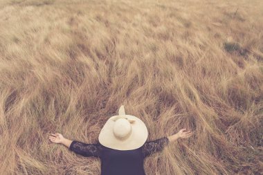 Kadın şapka ile yalan yüzünü sarı alan çim gizlemek. Sakin ol 