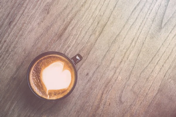 Горячий кофе латте в черной чашке на сером деревянном фоне стола. V — стоковое фото
