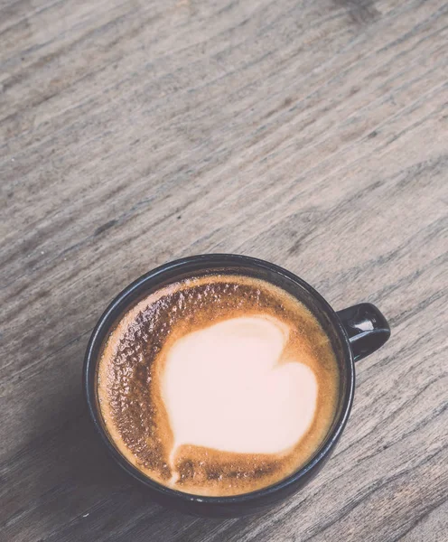 Горячий кофе латте в черной чашке на сером деревянном фоне стола. V — стоковое фото