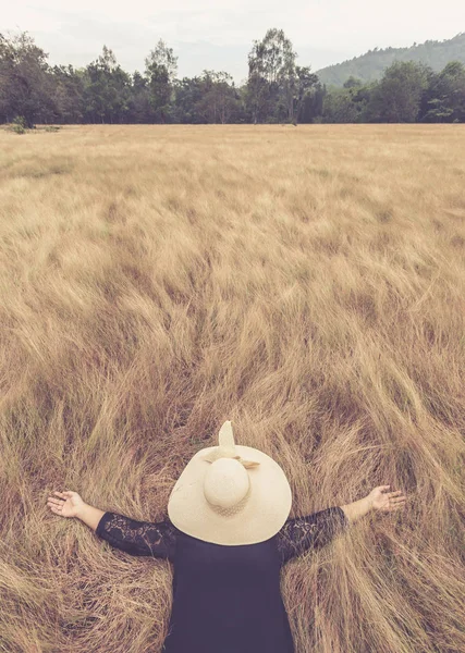 Kadın şapka ile yalan yüzünü sarı alan çim gizlemek. Sakin ol 