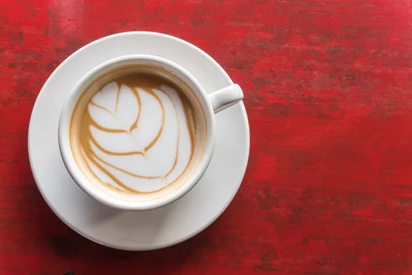 Bovenaanzicht hete latte koffie in witte cup op houten tafel — Stockfoto