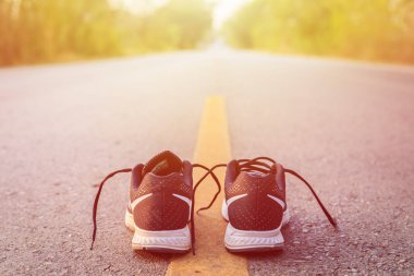 Yeni siyah koşu ayakkabıları sabah saat de asfalt yol