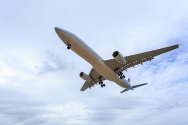 Mavi gökyüzü ve Tayland beyaz bulut altında uçan uçak