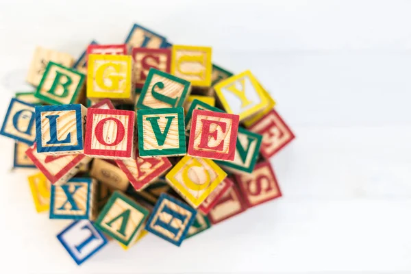 LOVE write in wooden alphabet block on white wooden background. — Stock Photo, Image