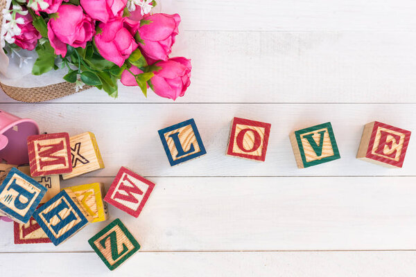 LOVE write in wooden alphabet block on white wooden background. 