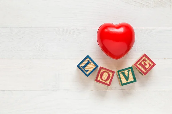 Vista dall'alto cuore rosso su tavola di legno bianco. Per amore o per San Valentino — Foto Stock
