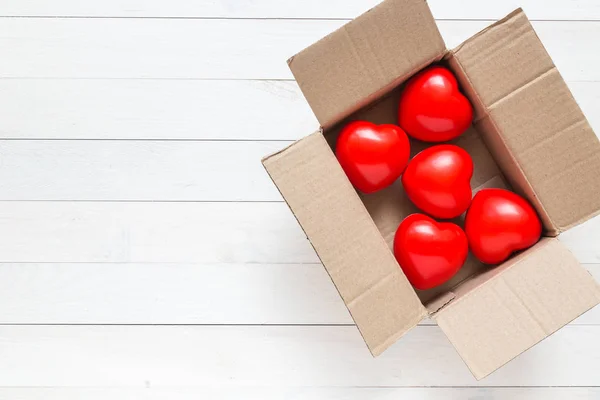 Top view red heart in brown box on white wooden plank. For love — Stock Photo, Image