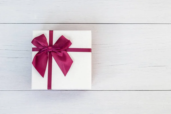 Caja de regalo de color vista superior con cinta en tablón de madera blanco — Foto de Stock