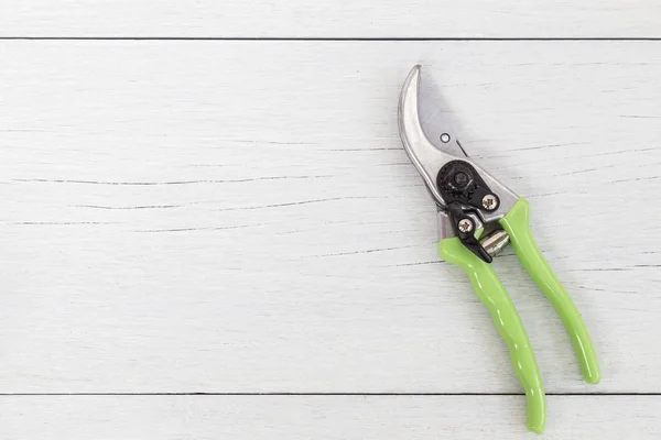 New green secateurs on white wooden. Top vie — Stock Photo, Image