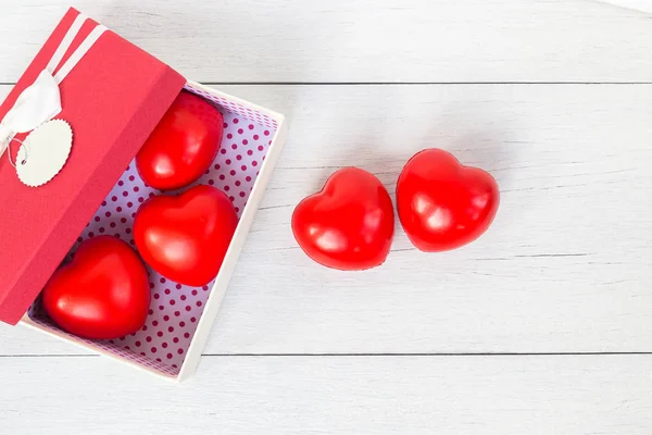 Top view red heart and gift box with ribbon on white wooden plan — Stock Photo, Image