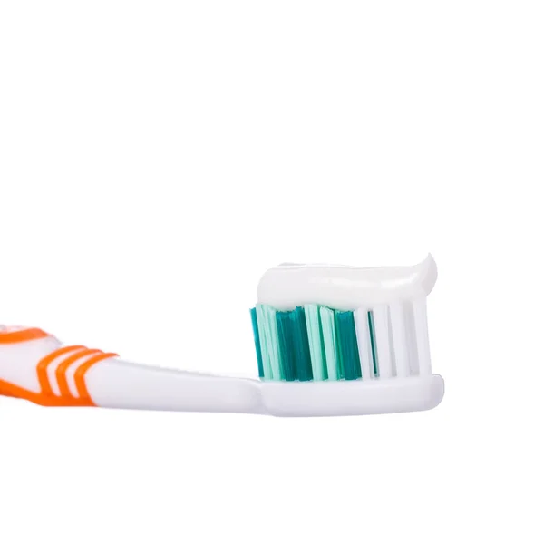 New orange toothbrush with toothpaste. Studio shot isolated on w — Stock Photo, Image