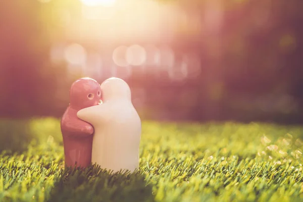 White and pink ceramic doll on green grass with blur bokeh and s — Stock Photo, Image