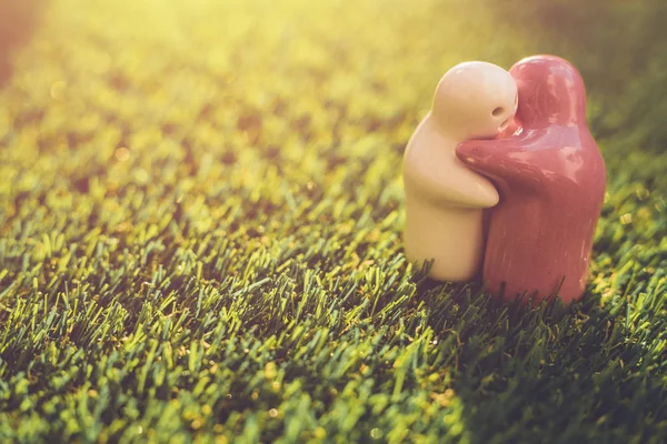 Biały i różowy lalki ceramiczne na zielonej trawie z rozmycie bokeh i s — Zdjęcie stockowe
