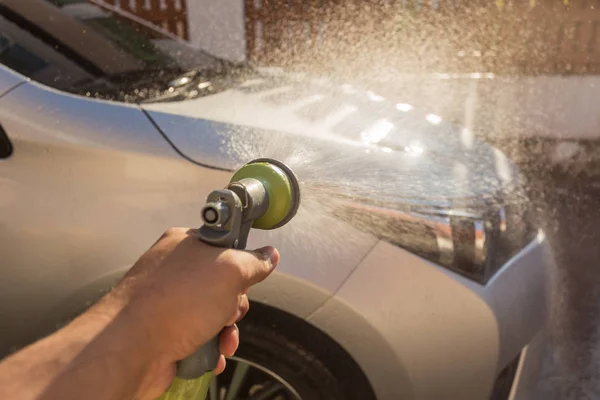 Hand spraying water for car wash. Private car washing. Focus on — Stock Photo, Image