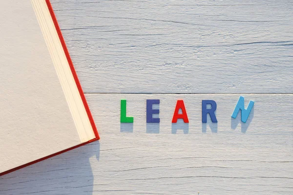 Régi könyv és tanulj színes ábécé szót. Felülnézet fehér woo — Stock Fotó