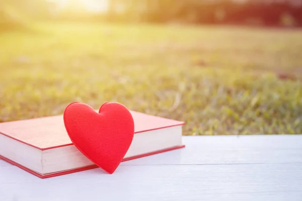 Rood hart en boek over witte houten dek. Voor liefde of Valentijn d — Stockfoto