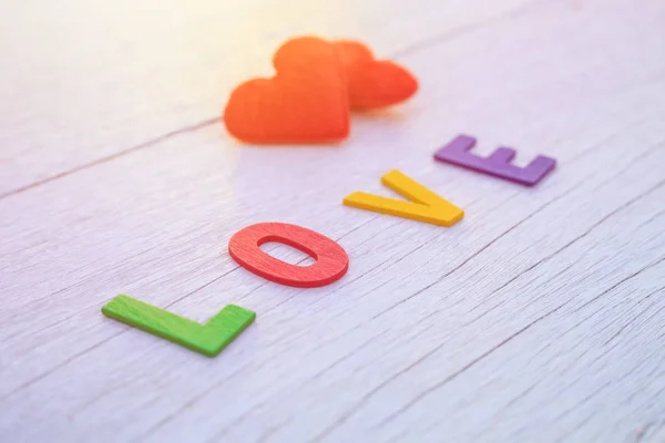 Alfabeto di legno colorato e parola LOVE. Vista dall'alto su legno bianco — Foto Stock