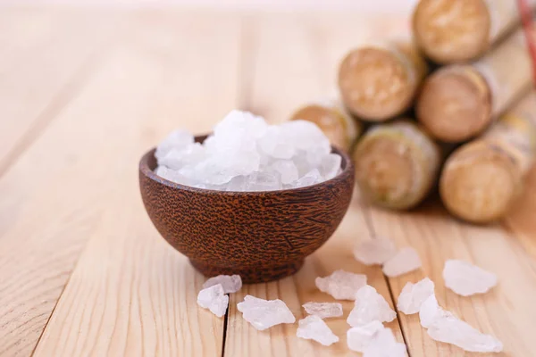 Açúcar de rocha e cana-de-açúcar sobre fundo mesa de madeira — Fotografia de Stock