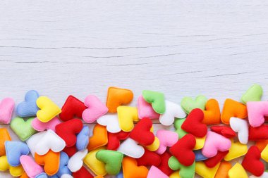 Beyaz ahşap tahta arka plan üzerinde renkli kalp şekli. Aşk için 