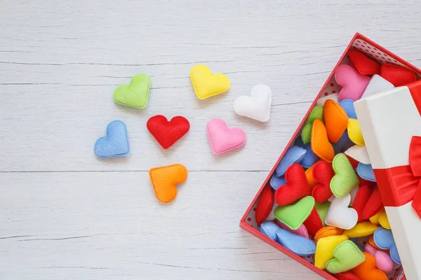 Colorful heart shape in gift box with ribbon on white wooden pla — Stock Photo, Image