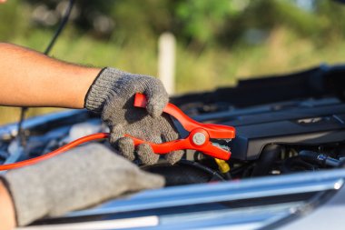 El araba teknisyeni kablo tutarak pil için bağlanmak için