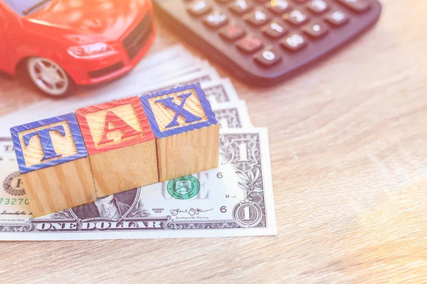 Daňové zápis v barevných abeceda dřeva box na nás dolar a červené auto, c — Stock fotografie