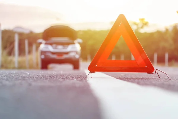 Señal roja de parada de emergencia y coche de plata roto en la carretera — Foto de Stock