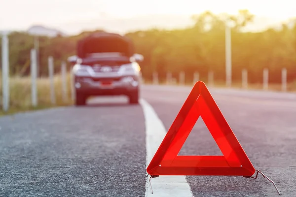 Red emergency stop sign and broken silver car on the road — Stock Photo, Image