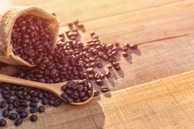 Ahşap masa küçük torba içinde kavrulmuş kahve çekirdekleri. Açık ateş etme