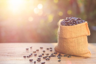 Ahşap masa küçük kahverengi torba siyah fasulye. Çekim açık