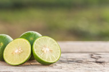 Ahşap masa arka plan üzerinde dilim yeşil taze limon 
