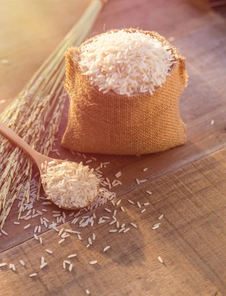 Тайського рису жасмин в ложку і невеликий мішок на дерев'яну столову фонової м — стокове фото